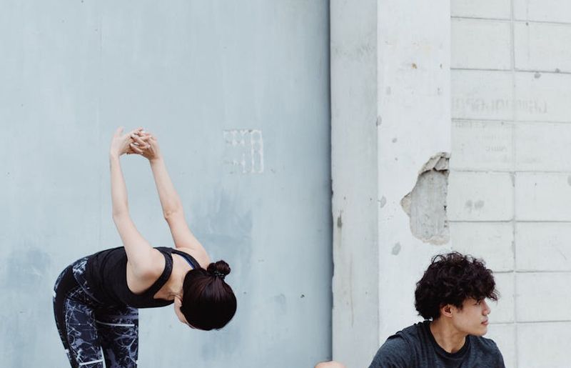 Man in mid-motion during a dynamic stretching exercise.